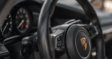 Detail van het stuur en dashboard van een Porsche (sfeerbeeld)